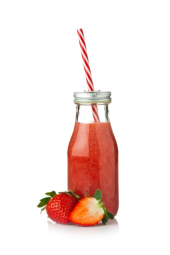 Strawberry smoothie in a glass bottle with a red and white drinking straw isolated on white background. At the base of the bottle is a whole strawberry and a half one. Predominant colors are red and white. DSRL studio photo taken with Canon EOS 5D Mk II and Canon EF 70-200mm f/2.8L IS II USM Telephoto Zoom Lens