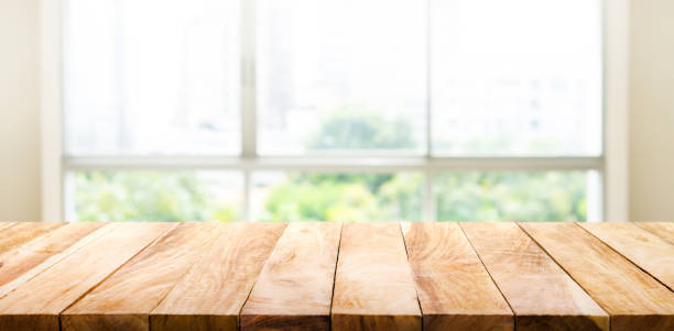 istock Wood table top on blur green garden from window view. 641868612