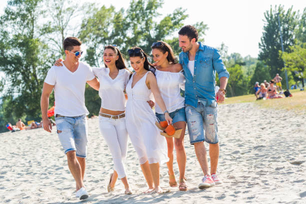 istock Group of young people holding hands on beach 641868820