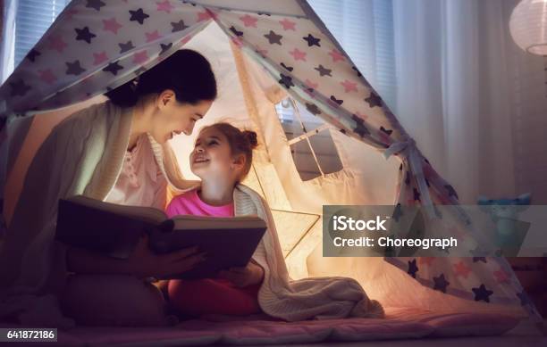 Mom And Child Are Reading Book Stock Photo - Download Image Now - Child, Electric Lamp, Night
