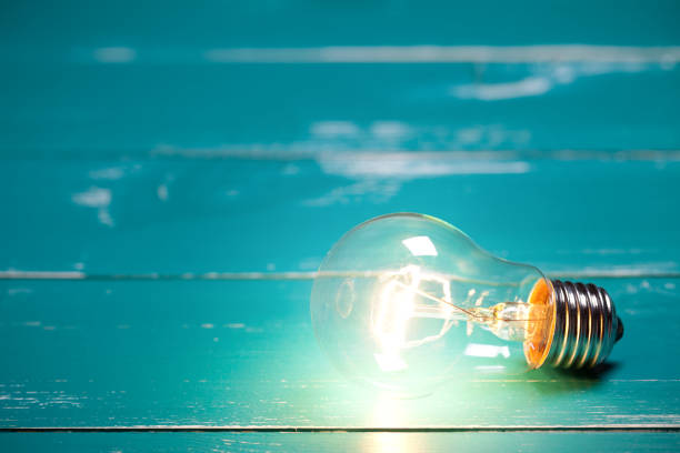 istock Vintage incandescent bulbs on turquoise wooden table 641873252