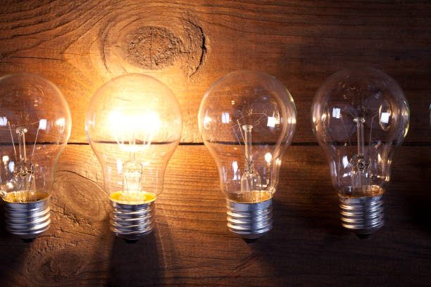 istock Vintage incandescent bulbs on old wooden table 641873462
