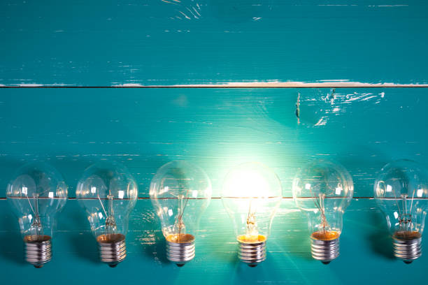 istock Vintage incandescent bulbs on turquoise wooden table 641873590