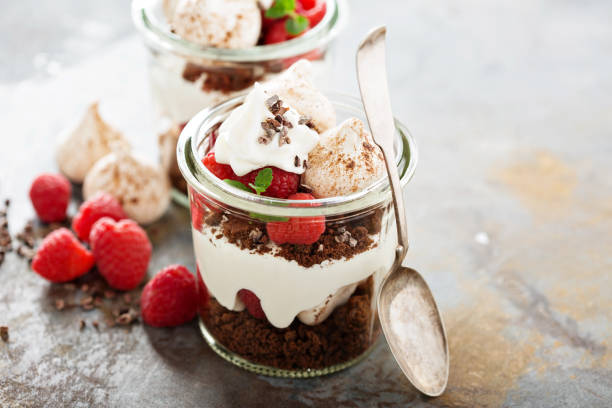 Layered dessert with chocolate cake and whipped cream Layered dessert with chocolate cake, whipped cream and raspberry in a jar cake jar stock pictures, royalty-free photos & images