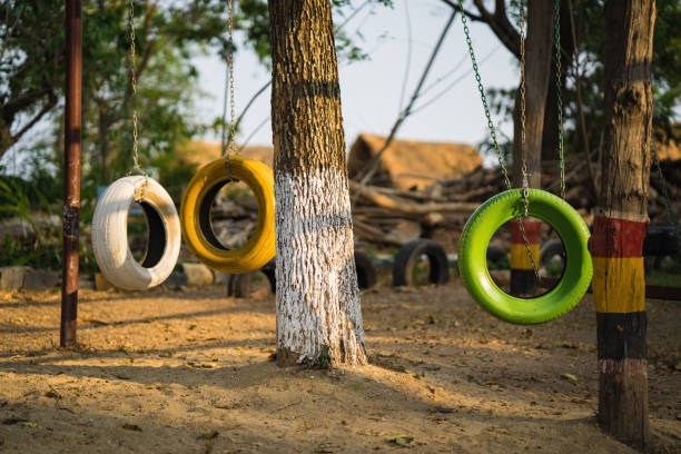 Swing chairs made from old tires for children in park.