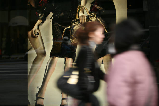 Tokyo, Japan - March 24, 2009: pedestrians walk past a shop window in Ginza. Ginza is the main area of boutiques in Tokyo.