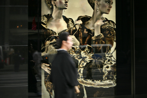 Tokyo, Japan - March 24, 2009: pedestrians walk past a shop window in Ginza. Ginza is the main area of boutiques in Tokyo.