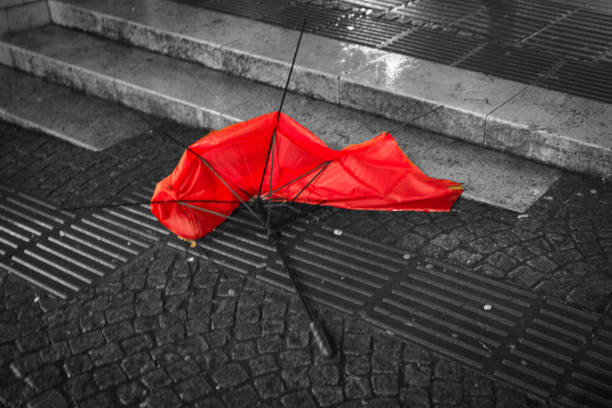 istock Broken red umbrella isolating the colour on the pavement at night in central Bristol. 641880466