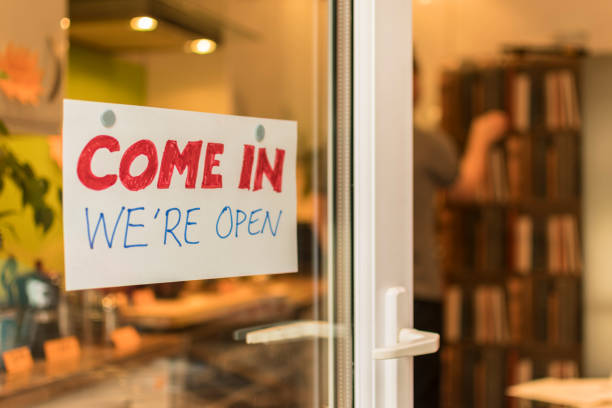 istock Man shopping in background, focus on Open Sign 641882954