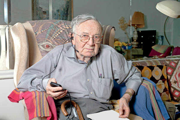 istock Senior man sitting on couch with headphone 641884524