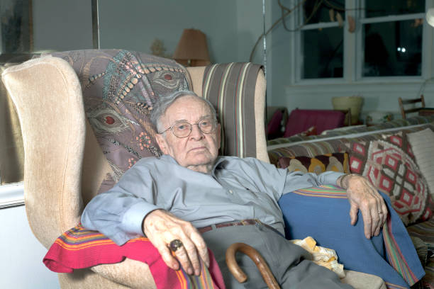 Senior man sitting on couch stock photo