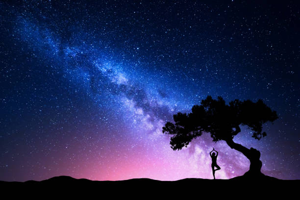 istock Milky Way with tree and a woman practicing yoga 641887634