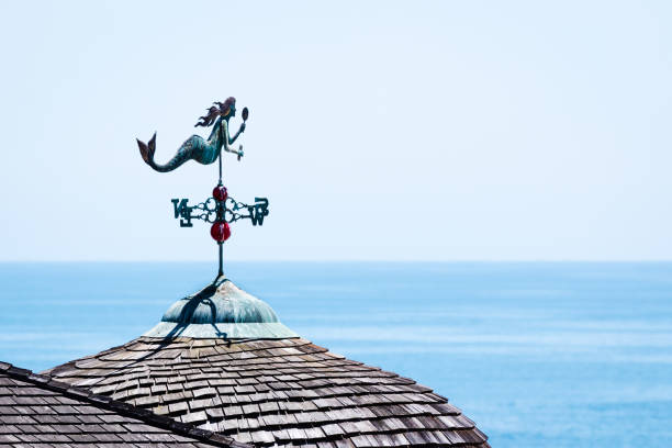 A copper patina mermaid weather vane overlooking the ocean.