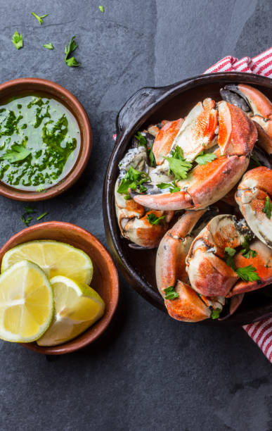 istock Crabs tentacles with lemon, herbs sauce on slate background 641894194