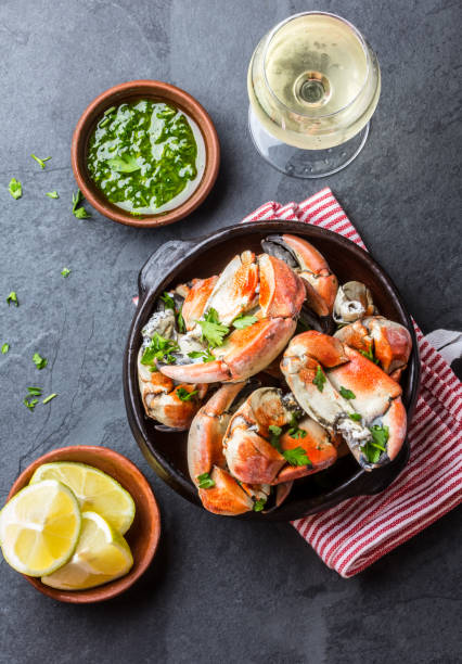 istock Crabs tentacles with wite wine, lemon, herbs sauce, slate background 641894624