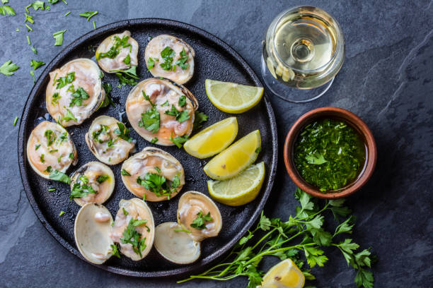 istock Raw clams with lemon, herbs and white wine, slate background 641900594