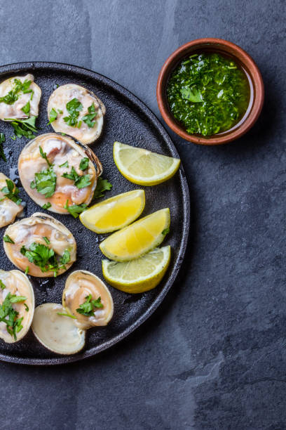 istock Raw clams with lemon, herbs and white wine, slate background 641903192
