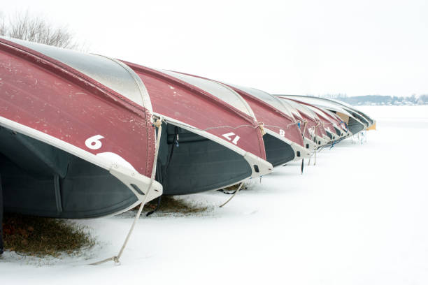 istock Boats line up on shore on a snow day. 641906730