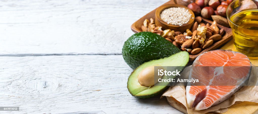 Selection of healthy fat sources food, life concept Selection of healthy fat sources food, salmon fish avocado olive oil pumpkin seeds nuts sesame on a white rustic wooden table Healthy Eating Stock Photo