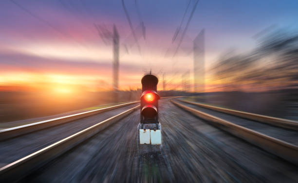 bahnhof und semaphore mit bewegungsunschärfe-effekt - railroad crossing train railroad track road sign stock-fotos und bilder