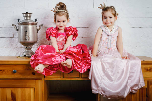 two little princess sitting on a wooden table