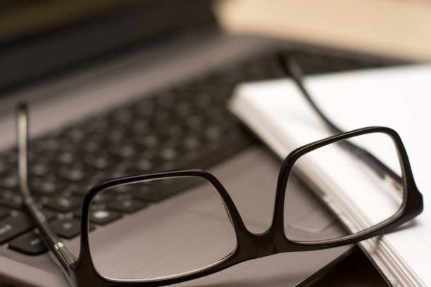 istock Office workplace with laptop, glasses and note book on wood table. 641912874