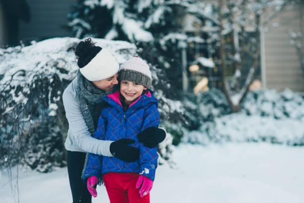 istock Mom Playing With Young Daughter in Snow 641918884