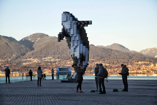 Feb-13-2017, Many people in front of whale statue at downtown area close to Canada Place, enjoying the sunset,Vancouver,Canada