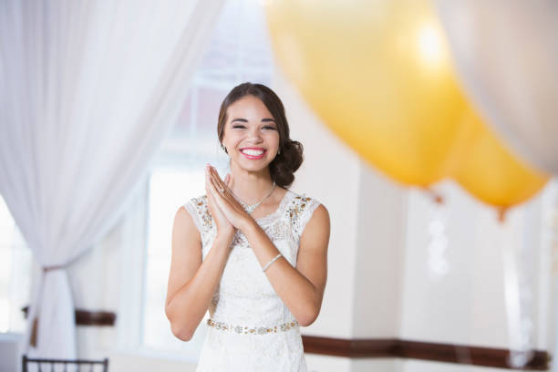 Portrait of a mixed race teenage girl wearing a white dress. She is ready for a special occasion, perhaps her prom or birthday party.