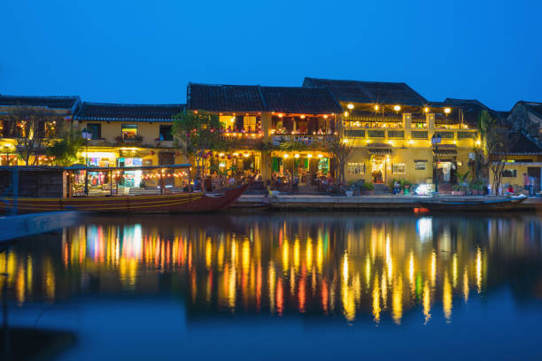 Quang Nam, Vietnam - Apr 1, 2016: Hoi An ancient town viewing from Thu Bon river by twilight period. Hoi An is UNESCO world heritage, one of the most popular destinations in Vietnam Quang Nam, Vietnam - Apr 1, 2016: Hoi An ancient town viewing from Thu Bon river by twilight period. Hoi An is UNESCO world heritage, one of the most popular destinations in Vietnam thu bon river stock pictures, royalty-free photos & images