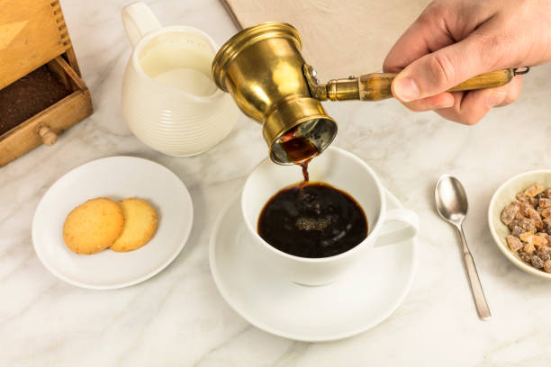 istock Coffee poured into cup, with milk jar and cane sugar 641930246