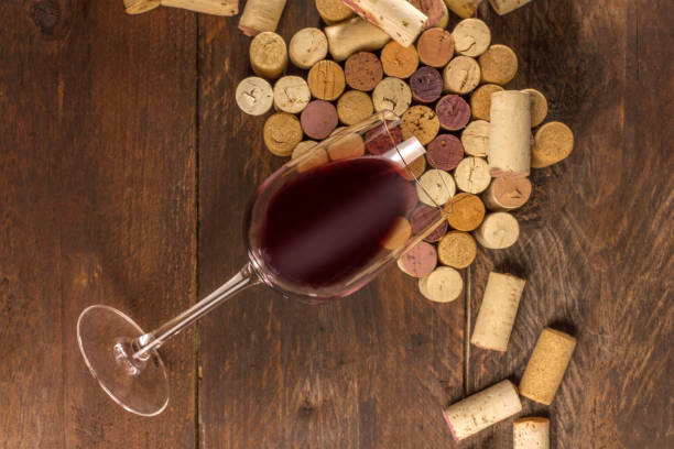 istock Glass of red wine and corks on dark background 641932020