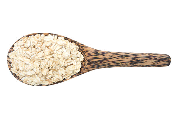 istock Oats in wooden spoon isolated top view on white 641940856