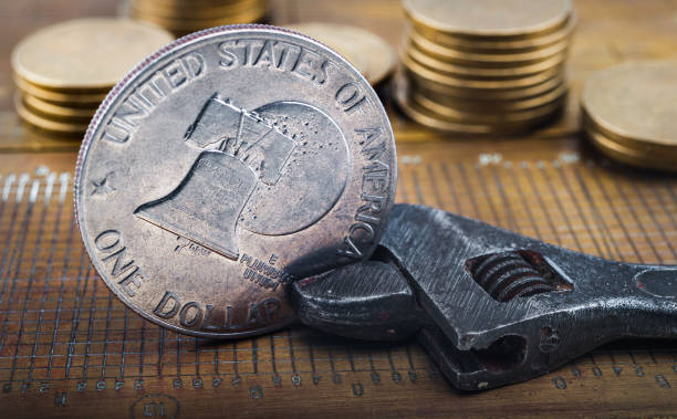 istock Coin one dollar clamped in an adjustable wrench 641942128