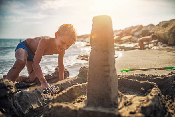 istock Little boy building sandcastle on italian beach 641943730