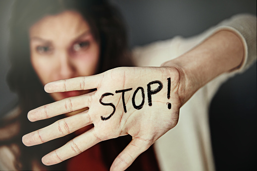 Portrait of a beaten and bruised young woman with the word 