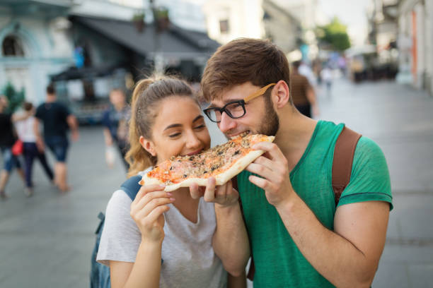 istock Happy students eating pizza on street 641951916