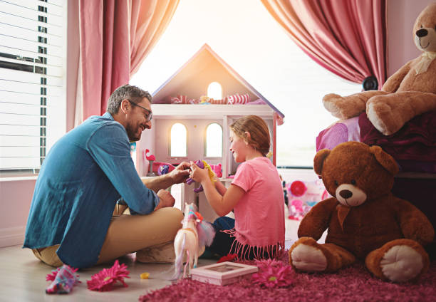 Indulging her imagination Shot of a father and daughter playing with a dollhouse together girl playing with doll stock pictures, royalty-free photos & images