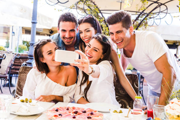 istock Beautiful people sitting in a restaurant and taking a selfie 641954900