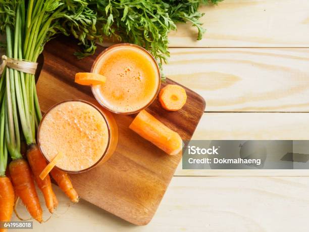 Top View Fresh Carrot Bundle And Juice On Plate Of Wooden Background Stock Photo - Download Image Now