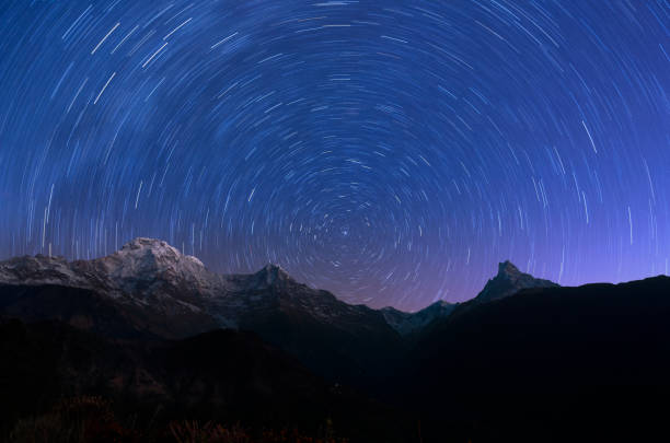 Circling stars and mountain Cicling stars and annapurna mountain region in night annapurna range photos stock pictures, royalty-free photos & images
