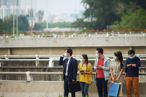 istock People in medical masks at bus stop 641962696