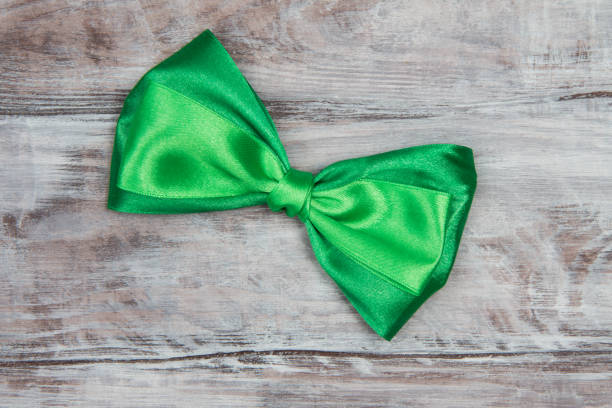 istock Green Satin bow tie on wooden background. St. Patricks Day 641963134