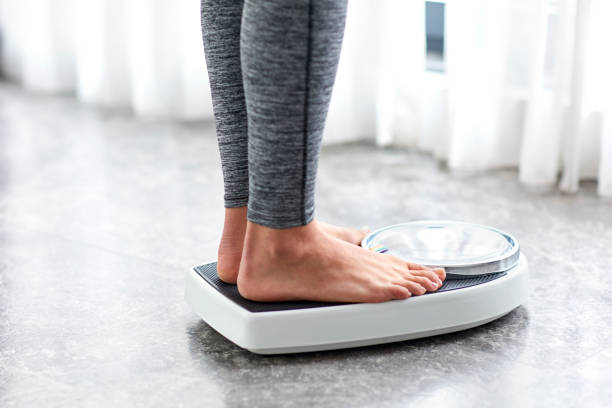Young healthy girl on home scales Young healthy girl on home scales weights photos stock pictures, royalty-free photos & images