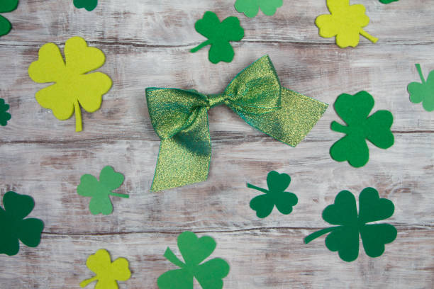 istock Green shiny bow and shamrocks on light wooden table. Patricks Day 641963446