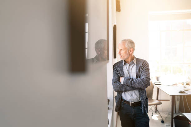 istock Businessman looking through window in office 641968272