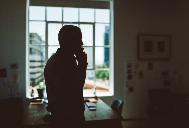 Businessman with hand on hip using smart phone