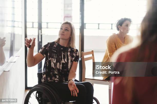 Disabled Businesswoman Giving Presentation Stock Photo - Download Image Now - Disability, Wheelchair, Office