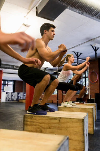 istock Athletes exercising on box at health club 641971124