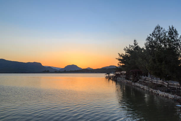 Free Stock Photo of Sun Setting Over Lake With Mountains in Background ...